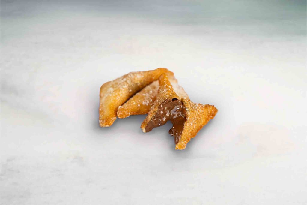Three golden, fried dough pockets filled with creamy Nutella, offering a sweet and indulgent dessert experience.
