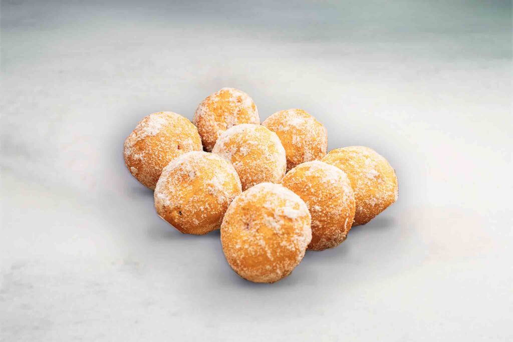 Eight fun-sized jam-filled donuts, freshly baked and fried, offering a crispy exterior with a sweet, fruity jam filling inside.