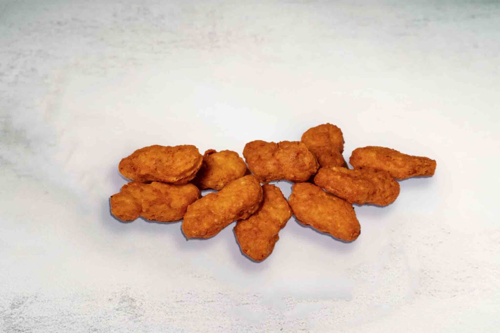 A serving of 10 crispy chicken nuggets, golden and battered, perfect for a snack or meal with dipping sauce.