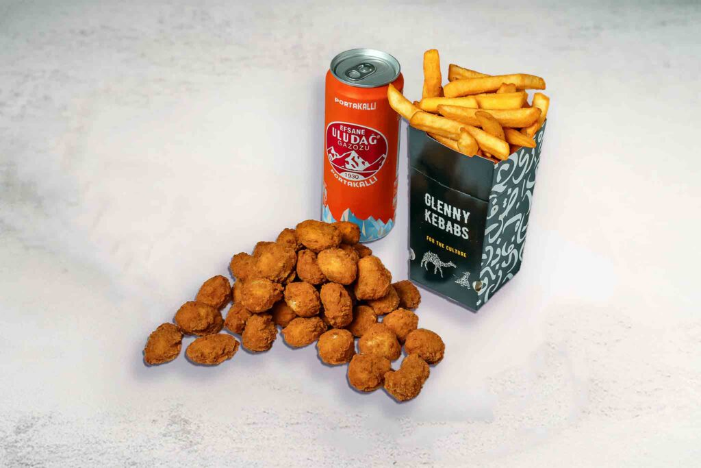 A serving of 10 crispy chicken nuggets, seasoned chips, and a refreshing soft drink, ideal for a complete meal or snack.