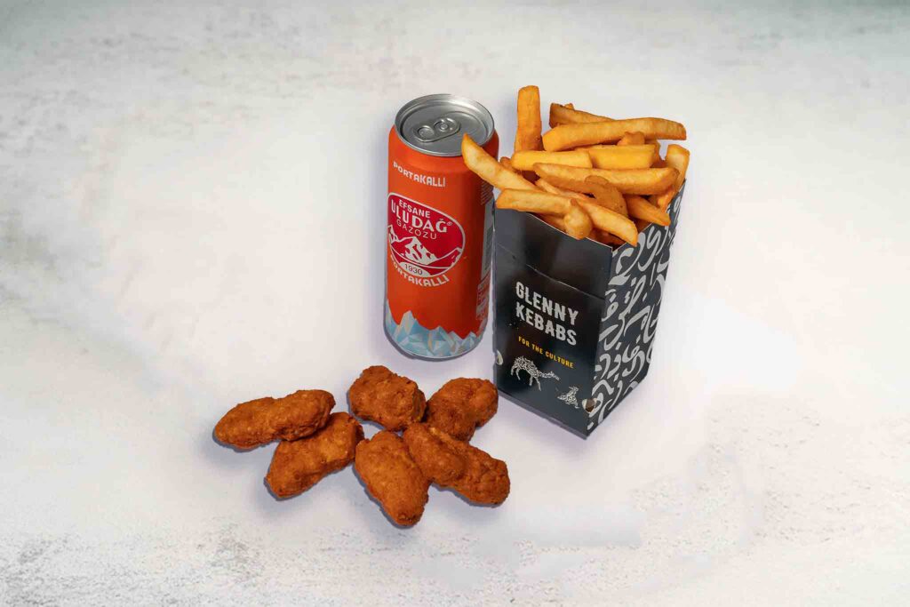 A serving of 6 crispy chicken nuggets with tomato sauce, regular seasoned chips, and a soft drink can, perfect for a quick meal or snack.