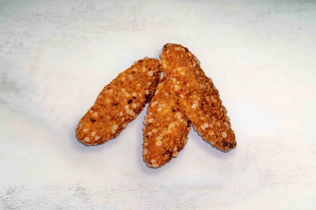 Image of 3 crispy chicken tenders served with dipping sauce, showcasing their golden-brown coating and juicy interior.
