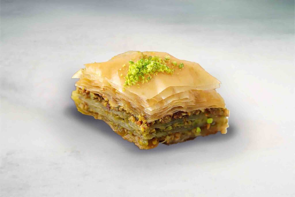 Pistachio baklava made with layers of phyllo pastry and filled with pistachio filling, baked golden and served in bite-sized pieces.