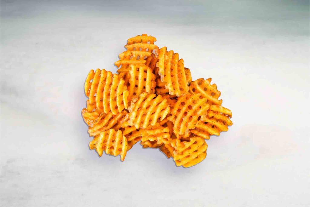 Image of golden, crispy cross-hatched waffle fries served with a side of creamy aioli dipping sauce.
